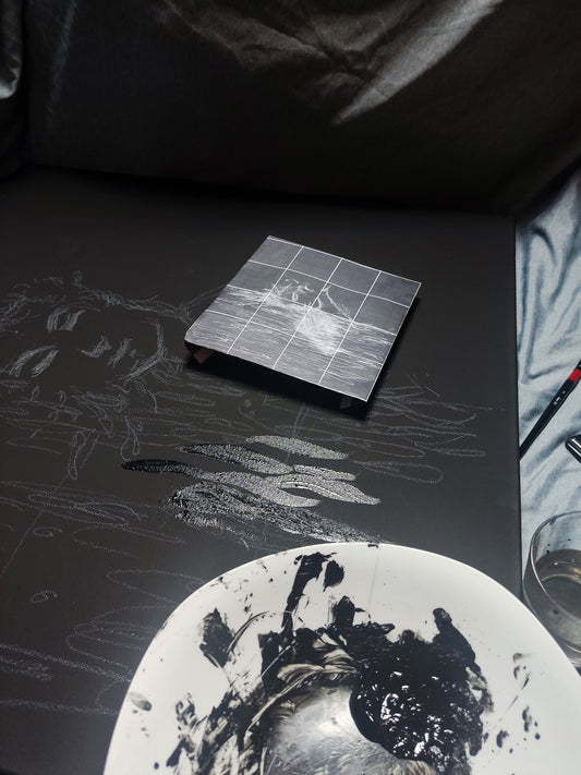Palette knife applying glossy acrylic paint on a matte black canvas in an attic studio space